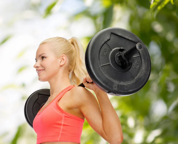 Glimlachende sportieve vrouw oefenen met lange halter — Stockfoto