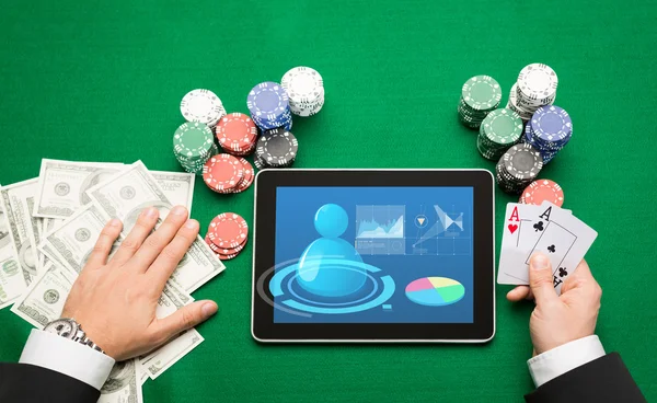 Joueur de poker casino avec cartes, tablette et jetons — Photo