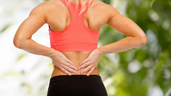 Close up of sporty woman touching her back Royalty Free Stock Photos