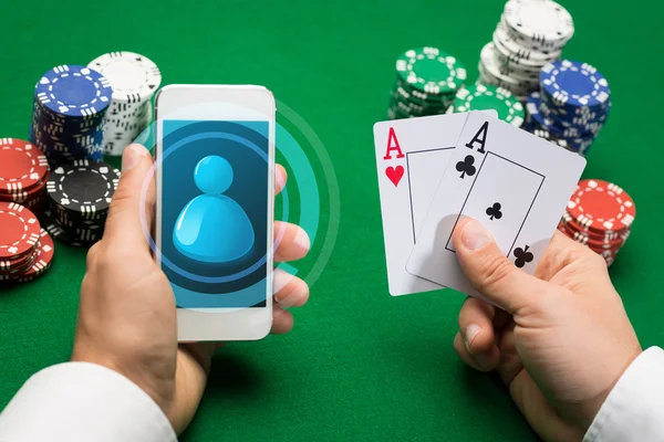 Jugador de casino con tarjetas, smartphone y fichas — Foto de Stock