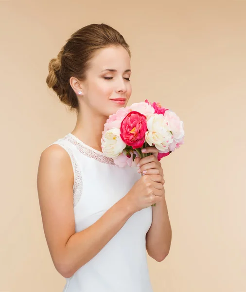 Mujer sonriente en vestido blanco con ramo de rosas —  Fotos de Stock