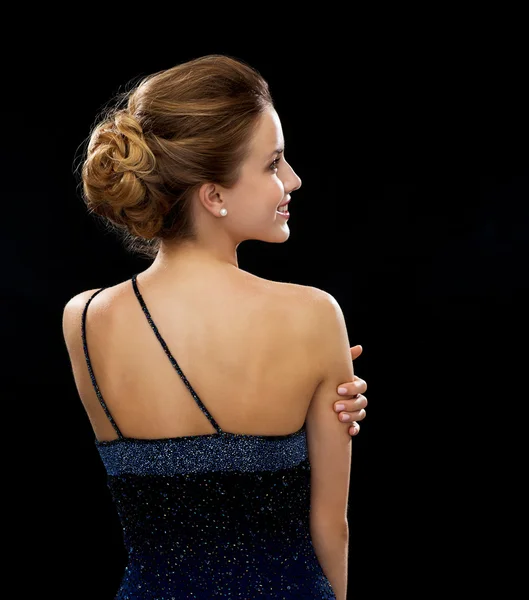 Mujer sonriente en vestido de noche desde la espalda — Foto de Stock