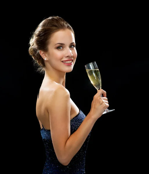 Usmívající se žena hospodářství sklenici šumivého vína — Stock fotografie
