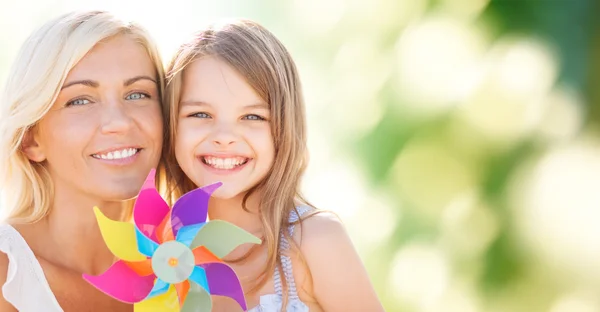 Glad mamma och liten flicka med vindsnurra leksak — Stockfoto