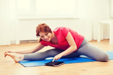 smiling teenage girl streching on floor at home clipart