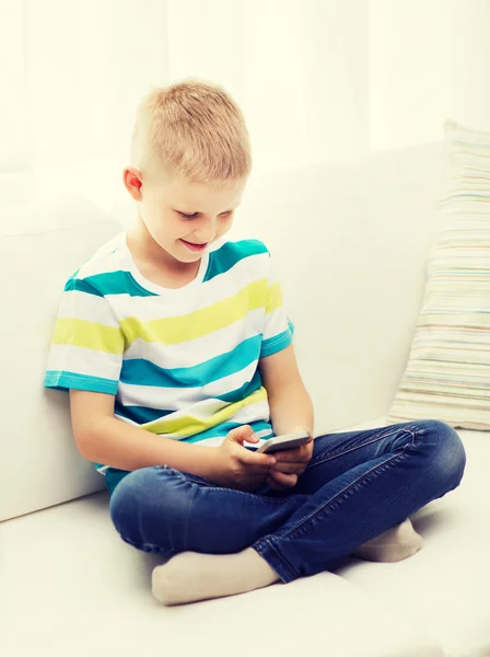 Lächelnder kleiner Junge mit Smartphone zu Hause — Stockfoto