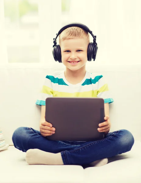 Niño pequeño con tablet PC y auriculares en casa — Foto de Stock