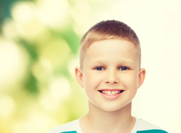 Lachende kleine jongen op groene achtergrond — Stockfoto