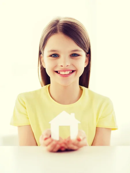 Niña sosteniendo casa de papel blanco — Foto de Stock