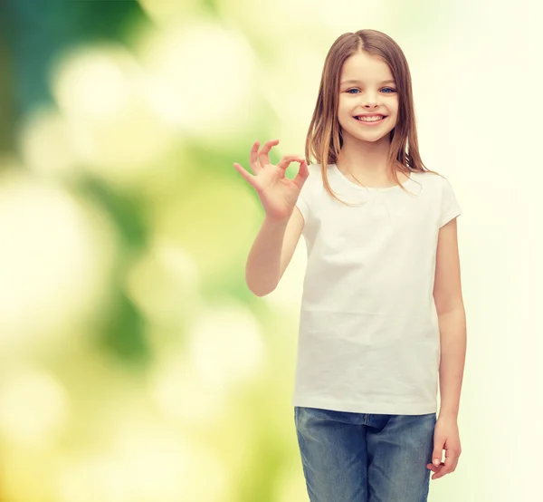 Маленькая девочка в белой футболке показывает жест ОК — стоковое фото