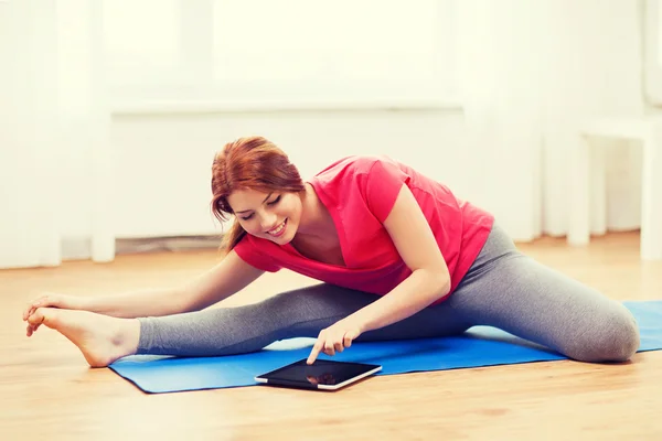 Smiling teenage girl streching on floor at home — Stock Photo, Image