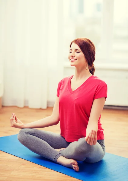 Smiling redhead teenager meditating at home — Stock Photo, Image