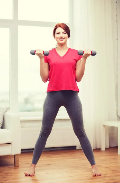 Souriant adolescent fille exercice avec haltères — Photo