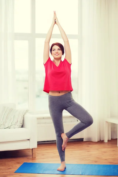 Sonriente pelirroja adolescente meditando en casa — Foto de Stock