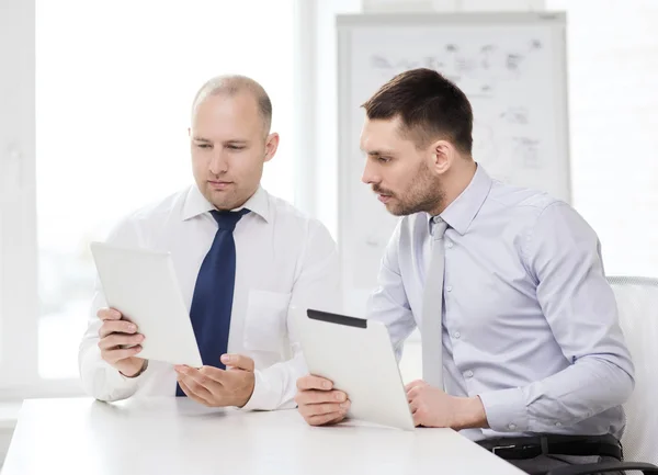 Dos hombres de negocios serios con la tableta PC en la oficina — Foto de Stock