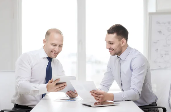 Dwóch biznesmenów uśmiechający się z komputera typu tablet w biurze — Zdjęcie stockowe