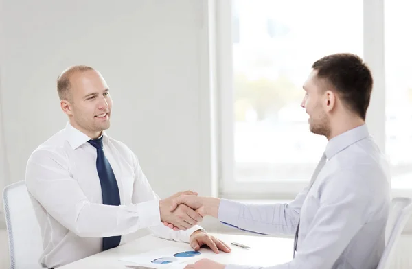 Twee Glimlachende zakenmensen schudden handen in office — Stockfoto