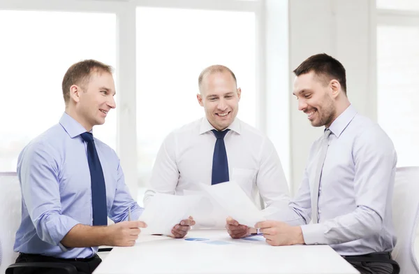 Lächelnde Geschäftsleute mit Papieren im Amt — Stockfoto