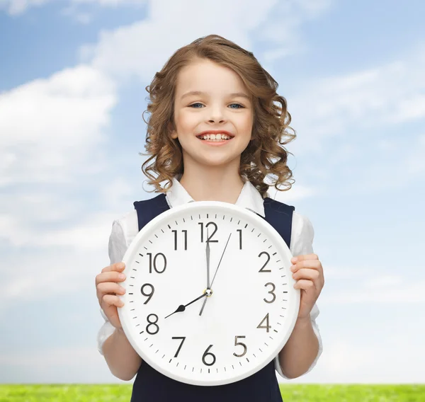 Sonriente chica sosteniendo gran reloj — Foto de Stock