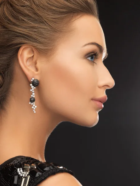 Femme portant des boucles d'oreilles en diamant brillant — Photo