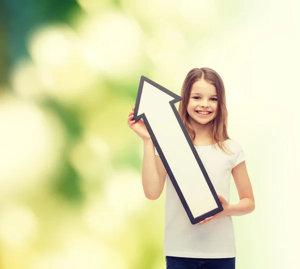 Petite fille souriante avec flèche vide pointant vers le haut — Photo