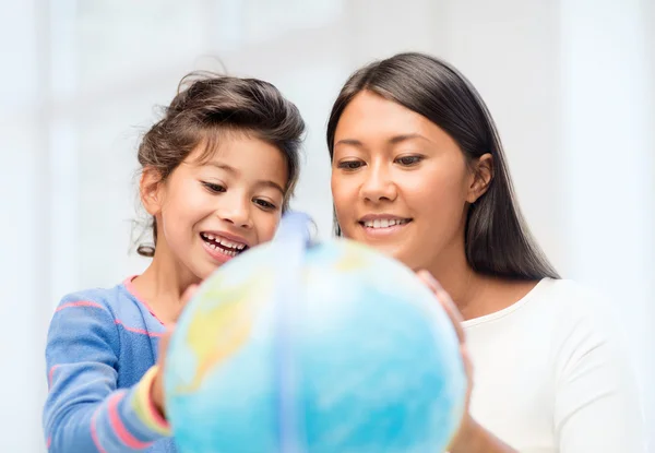 Mother and daughter with globe — Stock Photo, Image