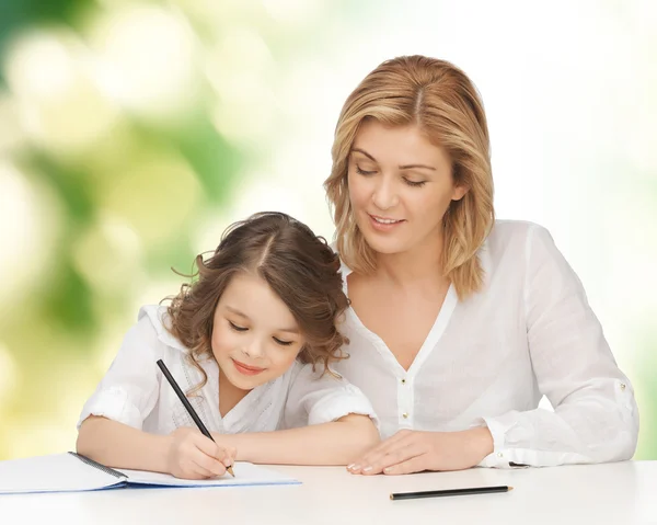 Mutlu anne ve kızı not defterinde yazma - Stok İmaj
