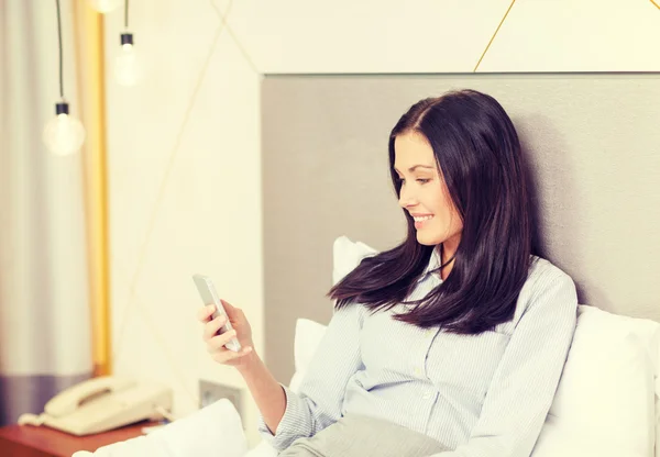 Empresária feliz com smartphone no quarto de hotel — Fotografia de Stock