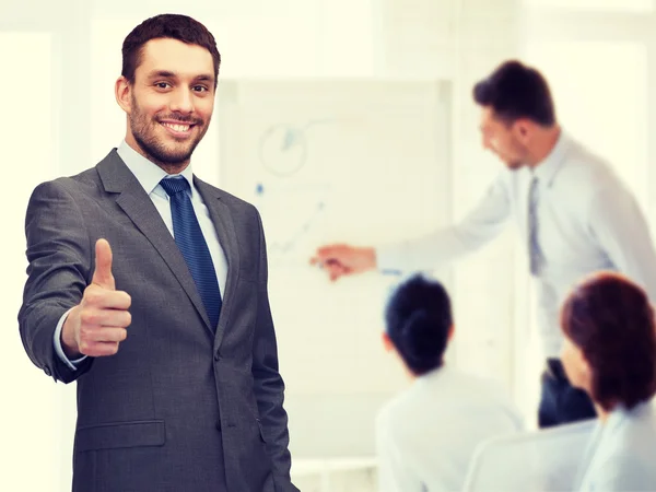 Bonito buisnessman mostrando polegares no escritório — Fotografia de Stock