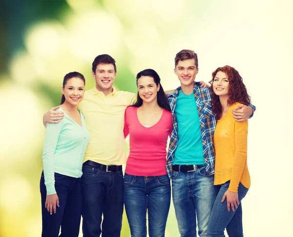 Skupina teenagerů usmívající se nad zeleným pozadím — Stock fotografie