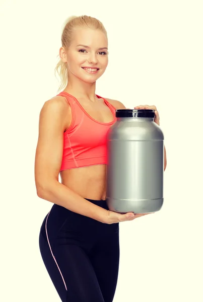 Glimlachend sportieve vrouw met pot van eiwitten — Stockfoto