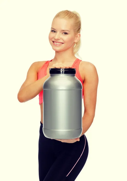 Mujer deportiva sonriente con tarro de proteína — Foto de Stock