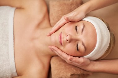 close up of young woman having face massage in spa clipart