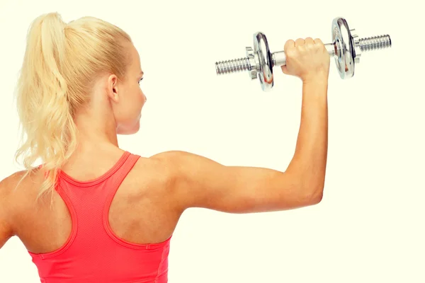 Sporty woman with heavy steel dumbbell from back — Stock Photo, Image