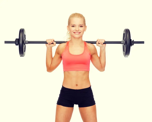 Sorrindo mulher desportiva exercitando com barbell — Fotografia de Stock