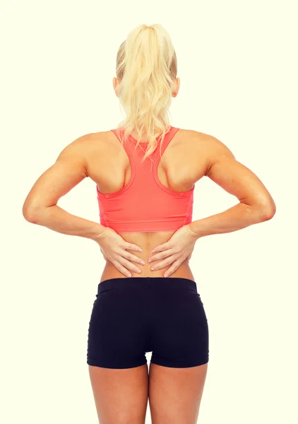 Sporty woman touching her back — Stock Photo, Image