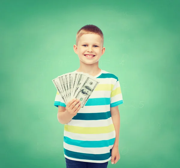 Sorrindo menino segurando dinheiro em dinheiro dólar em sua mão — Fotografia de Stock