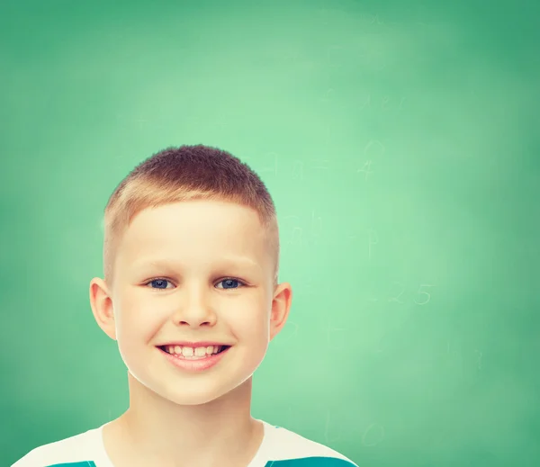 Smiling little boy over green board background — Stock Photo, Image