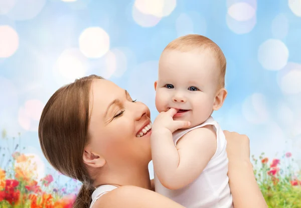 Gelukkig moeder met baby over natuurlijke achtergrond — Stockfoto