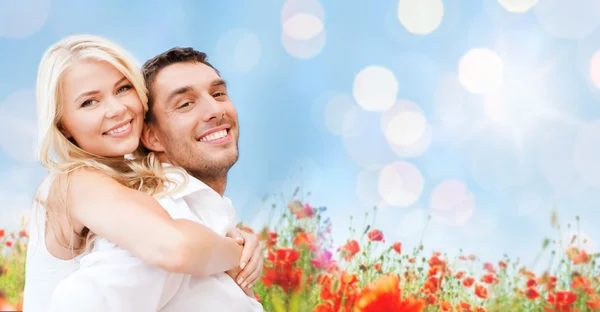 Couple heureux s'amuser sur le champ de fleurs de pavot — Photo