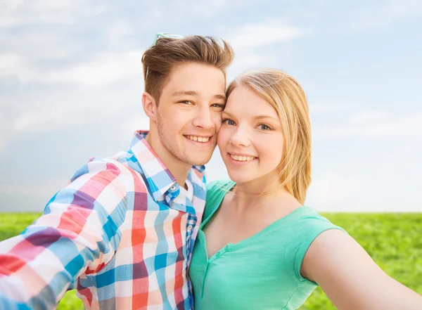 Smiling couple with smartphone in suburbs — Stock Photo, Image