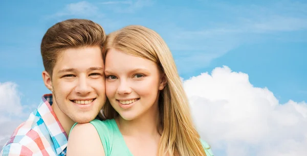 Sonriente pareja abrazándose sobre azul cielo fondo — Foto de Stock