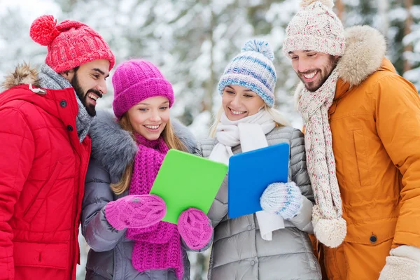 Amigos sonrientes con la tableta PC en el bosque de invierno — Foto de Stock