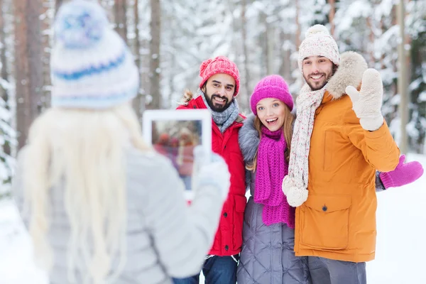 Smiling friends with tablet pc in winter forest — Stock Photo, Image