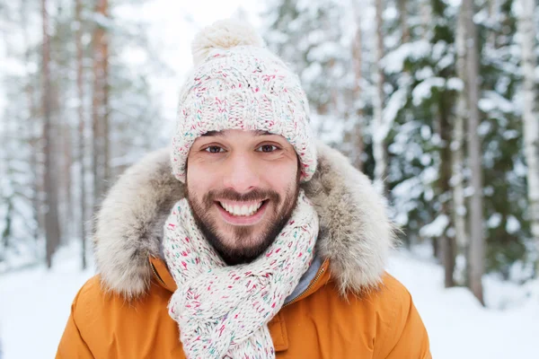 雪に覆われた冬の森で笑顔の若い男 — ストック写真