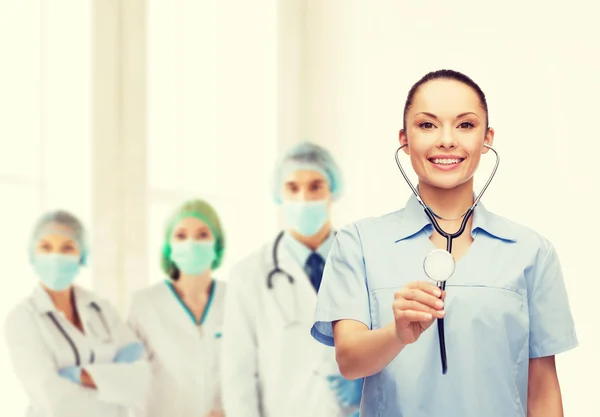 Médica ou enfermeira sorridente com estetoscópio — Fotografia de Stock