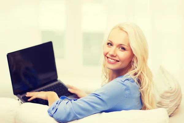 Mujer sonriente con ordenador portátil en casa —  Fotos de Stock