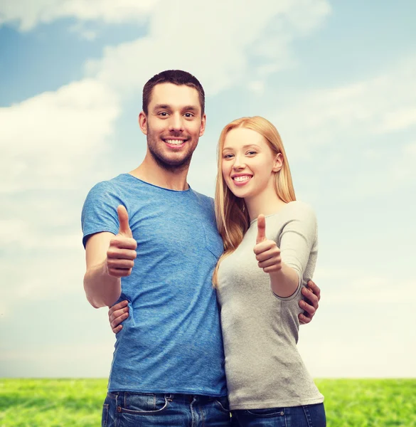 Smiling couple showing thumbs up — Stock Photo, Image