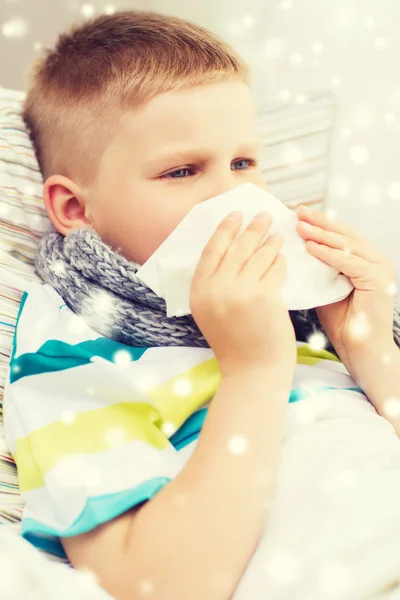 Sjuk pojke blåser näsan med vävnad hemma — Stockfoto