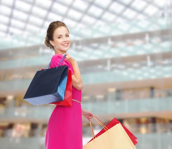 Mujer feliz joven con bolsas de compras sobre luces — Foto de Stock